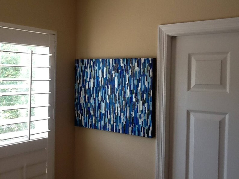 May include: Abstract painting with a blue, white and grey colour scheme. The painting is made up of many small, geometric shapes.