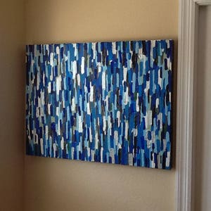 May include: Abstract painting featuring a blue, white and grey colour scheme. The painting is composed of numerous small, vertical lines.