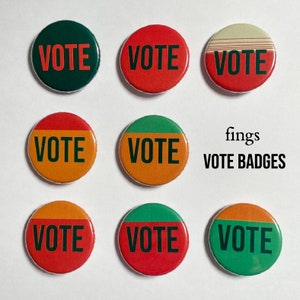 Puede incluir: Nueve insignias redondas y coloridas VOTE con diferentes combinaciones de colores. Las insignias tienen un fondo blanco con texto negro. El texto en las insignias dice "VOTE".