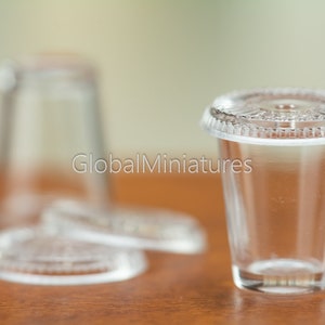 May include: A clear plastic cup with a lid, perfect for serving small portions of drinks or desserts. The cup is made of durable plastic and is dishwasher safe.