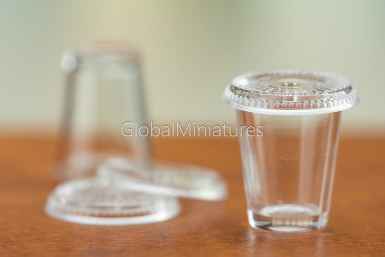 May include: A clear plastic cup with a lid, perfect for serving small portions of drinks or desserts. The cup is made of durable plastic and is dishwasher safe.