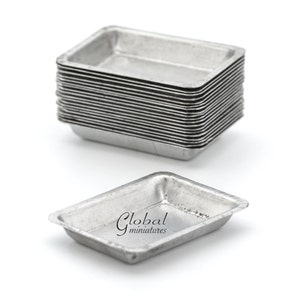 May include: A stack of 15 silver metal baking dishes, each measuring approximately 3 inches by 4 inches. The dishes are stacked on a white surface. The text "Global miniatures" is visible on the bottom dish.