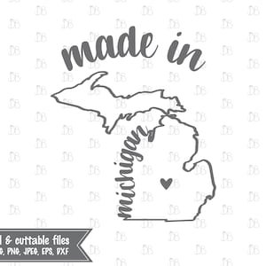 May include: A black and white outline of the state of Michigan with the text "made in" above it and "michigan" written vertically along the left side of the state. A small heart is in the lower left corner of the state.