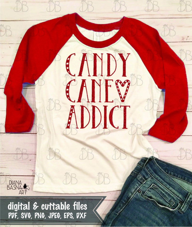Peut inclure: Un t-shirt de baseball blanc et rouge avec le texte "CANDY CANE♡ ADDICT" en lettres scintillantes rouges. Le t-shirt est pos&eacute; sur une surface en bois avec un jean bleu.