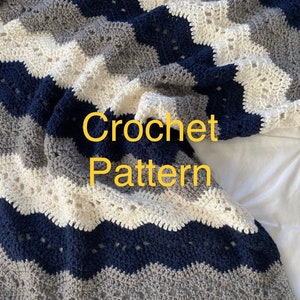 May include: Crochet pattern for a chevron blanket in shades of white, gray, and navy blue.
