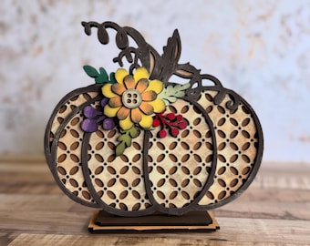 May include: Wooden pumpkin decoration with a lattice design, brown outline, and a decorative flower with a button center. The pumpkin is on a small wooden base, perfect for fall decor.