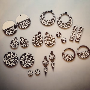 May include: Assortment of laser cut wooden earrings in various shapes and sizes. The earrings feature a white and brown damask pattern.