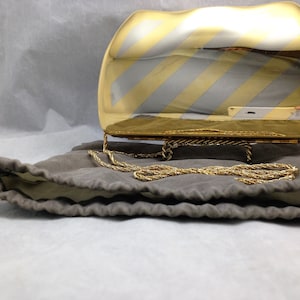 Cartera de noche totalmente de metal con cuerpo en tono plateado y detalles en tono dorado de 6 3/4 x 4 con correa de cadena de cuerda 04229