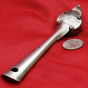May include: Silver can opener with a long handle and a circular opening at the end. The opener has the text "C.E.D. Patent Pending Troy, N.Y." on the circular opening.