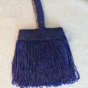 Monedero de muñeca con cuentas estilo años 20 de color azul oscuro y flecos de cuentas azules. Número de fabricante: 04888