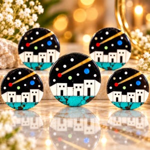 May include: Five circular inlays featuring a black night sky with a yellow comet, white stars, and a blue planet above a row of white buildings and a turquoise ground. The design includes small red, green, and blue circular accents.