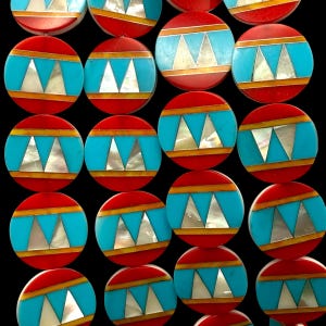 May include: A collection of circular buttons featuring a central horizontal band of bright turquoise inlaid with two white mother-of-pearl triangles. The turquoise band is bordered by thin orange stripes, with red circular edges completing the design.