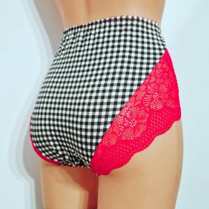 May include: High-waisted underwear with a black and white gingham pattern. The sides feature bright red lace trim. The underwear is displayed on a mannequin.