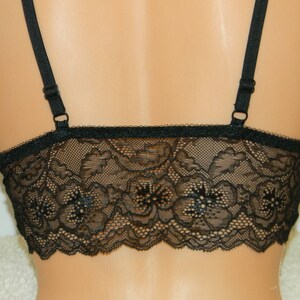 May include: Black lace bralette with adjustable straps. The bralette has a delicate floral pattern and is made of soft, stretchy lace.