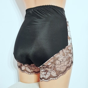 May include: Black high-waisted underwear with a satin finish. The sides feature a floral lace design in shades of brown and pink. The elastic waistband is scalloped.