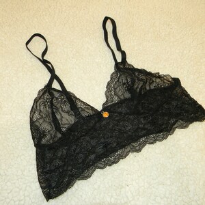 May include: Black lace bralette with adjustable straps and a delicate floral pattern.