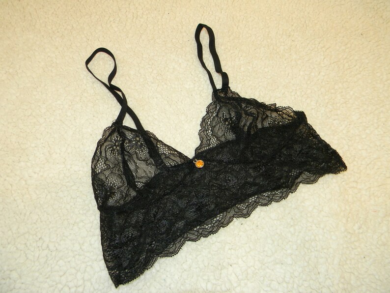 May include: Black lace bralette with adjustable straps and a delicate floral pattern.