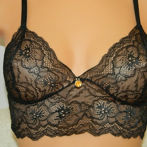 May include: Black lace bralette with adjustable straps and a small jewel accent in the center.