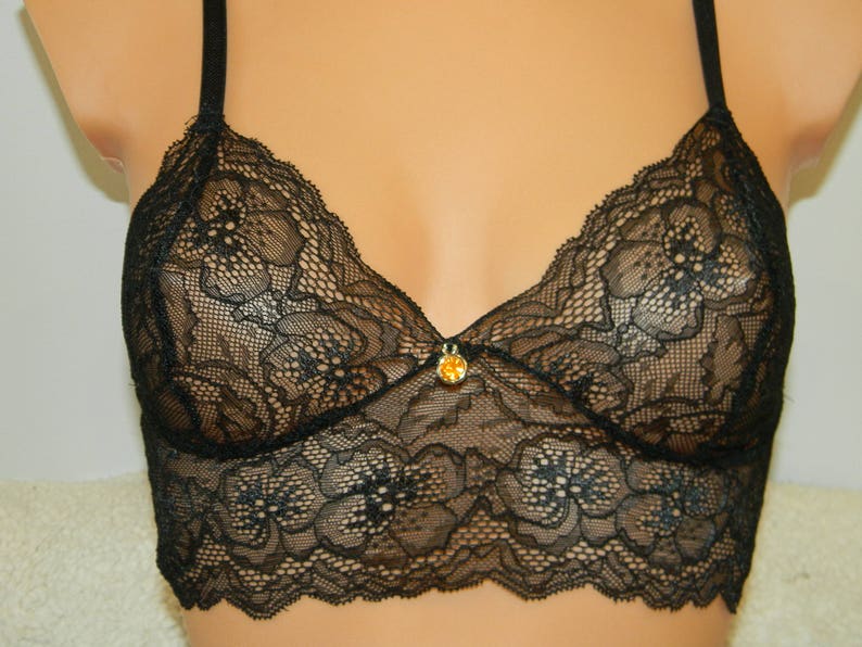 May include: Black lace bralette with adjustable straps and a small jewel accent in the center.