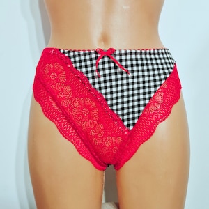 May include: Red lace and black and white gingham print underwear. The underwear features red lace trim along the sides and a small red bow at the front. The center panel has a black and white gingham pattern.