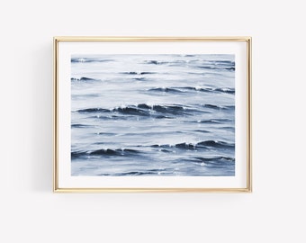 May include: A framed painting of a blue ocean with waves. The painting is in a gold frame.