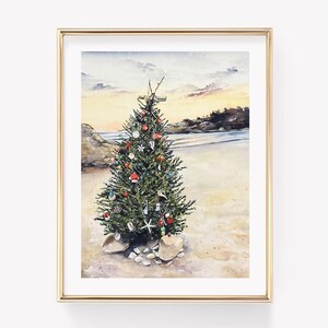 May include: Watercolor painting of a Christmas tree decorated with ornaments on a sandy beach. The tree is surrounded by rocks and seashells. The background features a sunset over the ocean, with a golden frame.