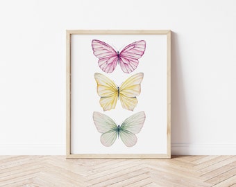 Peut inclure: Une impression encadrée représentant trois papillons aquarelle disposés verticalement. Le papillon du haut est rose, le papillon du milieu est jaune et le papillon du bas est vert.
