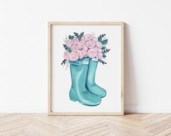 Op de afbeelding: Een paar turquoise regenlaarzen met een boeket roze rozen erin. De laarzen hebben het woord "Hunter" erop gedrukt.