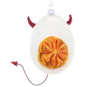 Peut inclure: Une décoration de Noël en forme d'œuf blanc avec un thème diabolique. Elle présente des cornes rouges à paillettes, une queue de diable et un centre en forme de jaune d'œuf. La décoration est suspendue à un capuchon et une ficelle argentés.