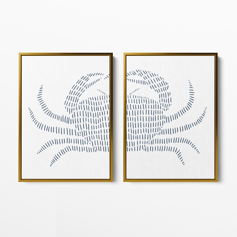 May include: A set of two framed prints featuring a stylized blue crab design on a white background. The frames are gold.