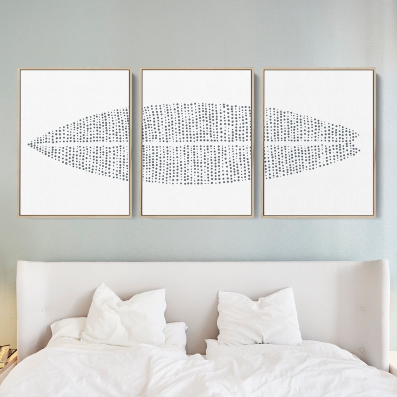 May include: A set of three abstract art prints with a white background and a gray geometric pattern of dots. The prints are framed in a natural wood frame.