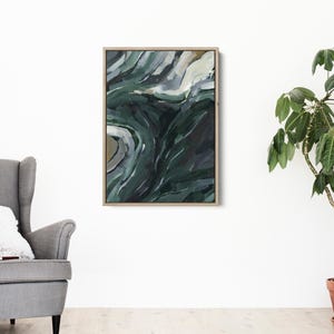 May include: Abstract painting with swirling green, blue, and white colors. The painting is framed in a light wood frame.