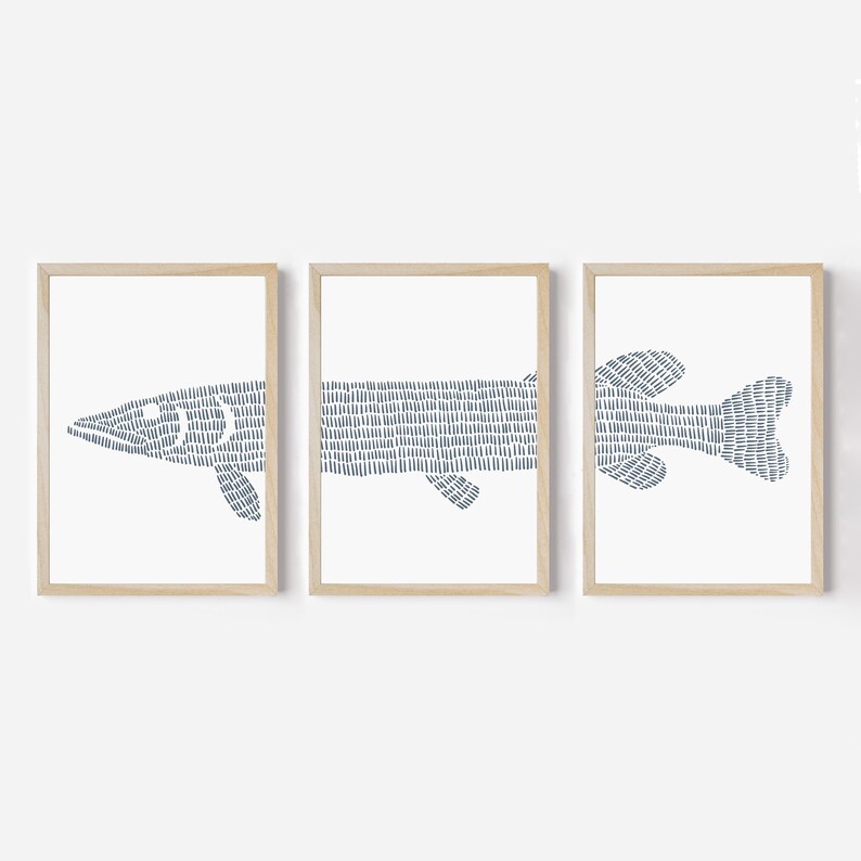 May include: Set of three framed prints featuring a stylized blue fish illustration. The fish is depicted in a minimalist style with a hatched pattern.