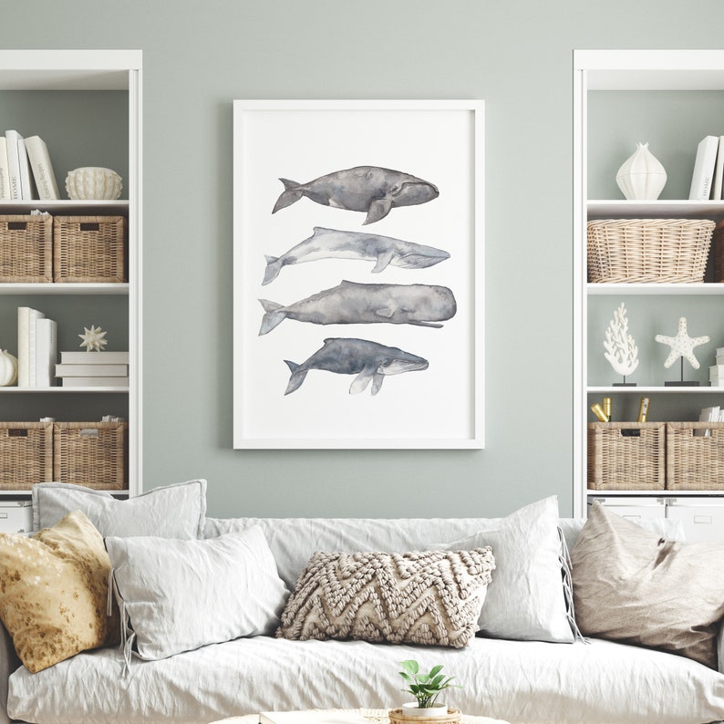 May include: A watercolor print of four whales in shades of gray, arranged vertically in a white frame. The whales are depicted in a minimalist style, with simple lines and subtle shading.
