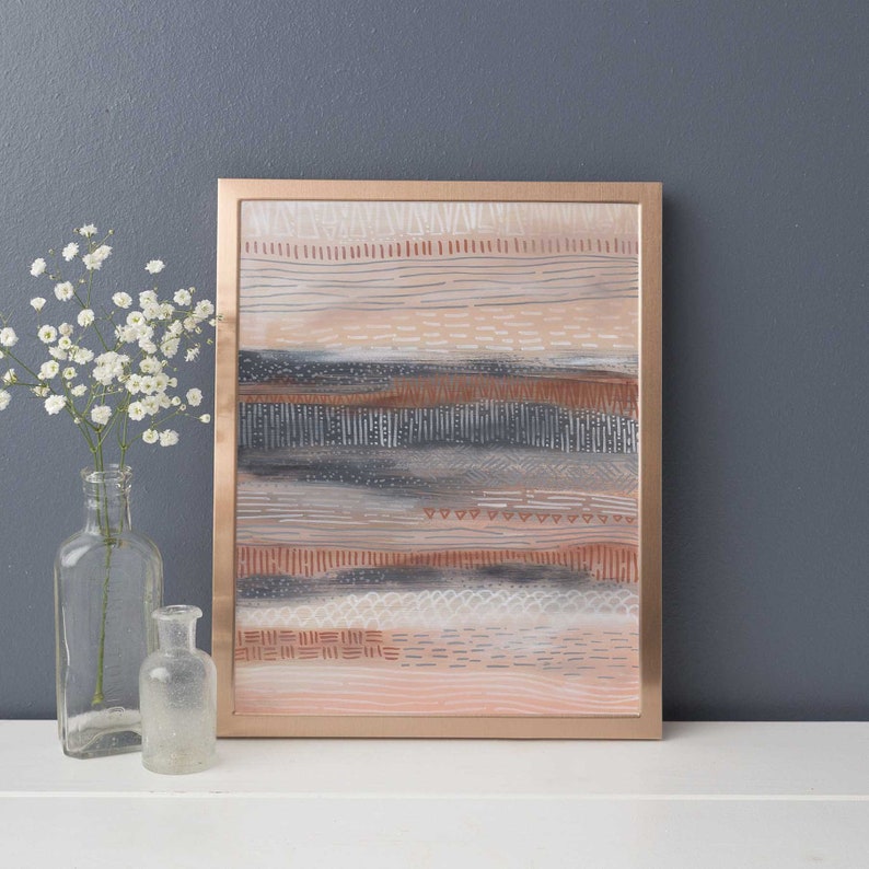 May include: Abstract art print with a copper frame. The print features a layered design of horizontal lines and patterns in shades of pink, brown, gray, and white.