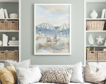 May include: A white framed painting of a beach scene with two striped umbrellas and people sitting under them. The painting is in a muted blue and beige color palette.