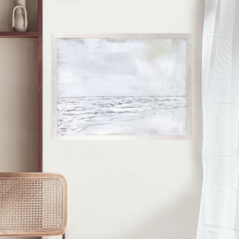 May include: A framed black and white sketch of a seascape with waves crashing on the shore. The background is a light gray with a hint of green.