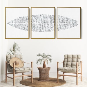 May include: Three framed abstract art prints with a white background and a pattern of small gray dots arranged in a wave-like design. The frames are gold.