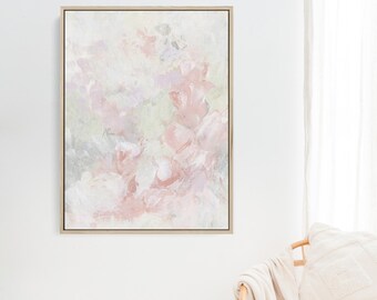 May include: Abstract painting with soft pink, white, and gray brushstrokes. The painting is framed in a light wood frame.