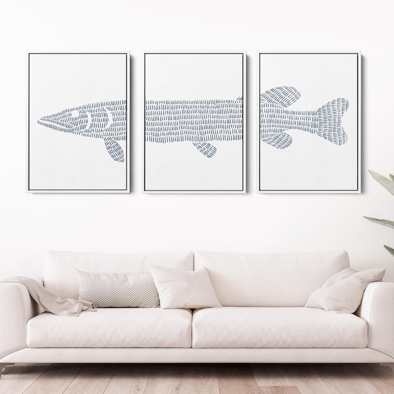 May include: Set of three framed prints featuring a stylized blue fish design. The fish is made up of a series of small lines, creating a textured look. The prints are set against a white background.