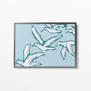 May include: A framed abstract painting of white birds flying in a teal blue sky.