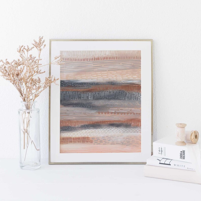 May include: A framed abstract art print with a layered design of horizontal stripes in shades of brown, gray, and white. The print has a textured look and is framed in a silver frame.