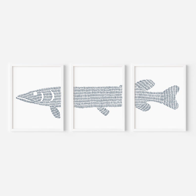 May include: Set of three framed prints featuring a stylized blue fish design. The fish is made up of a series of small lines.
