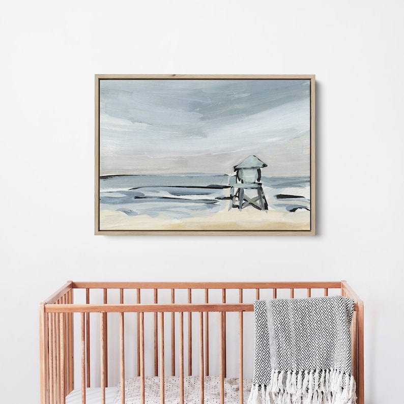 May include: A painting of a beach scene with a lifeguard stand in the distance. The sky is a light blue with gray clouds, and the water is a light blue with white waves. The sand is a light brown.