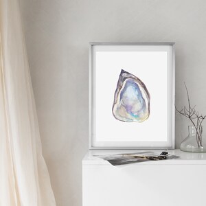 May include: A framed watercolor painting of a single oyster shell with a purple, blue, and white iridescent interior. The shell is painted in a realistic style and is set against a white background.