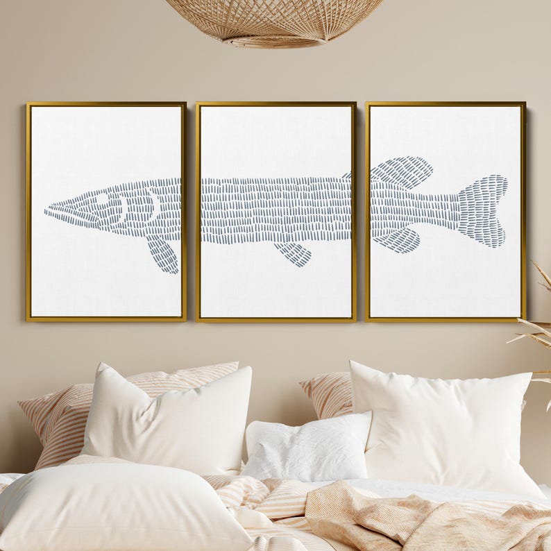 May include: A set of three framed prints featuring a stylized blue fish design on a white background. The fish is made up of small, repeated lines.