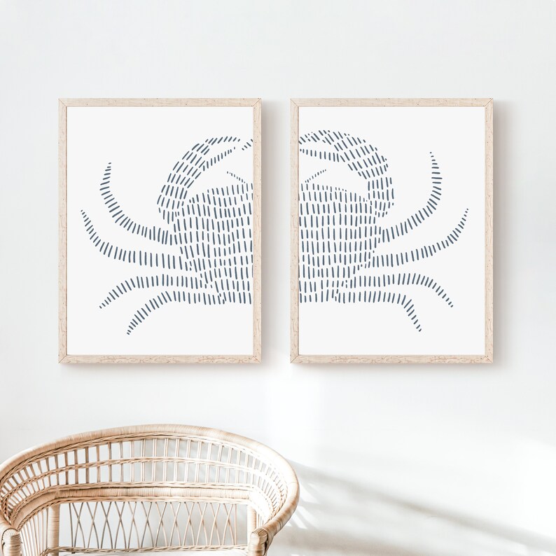 May include: Two framed prints of a stylized crab design in blue on a white background. The crab is made up of a series of vertical lines.