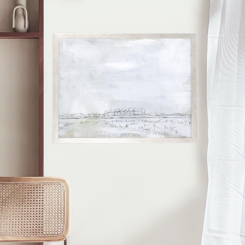 May include: A framed black and white minimalist landscape painting with a light gray background and a line drawing of a field with trees in the distance.