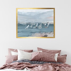 May include: Abstract painting of sailboats on a blue and grey sea with a sandy beach in the foreground. The painting is framed in gold.