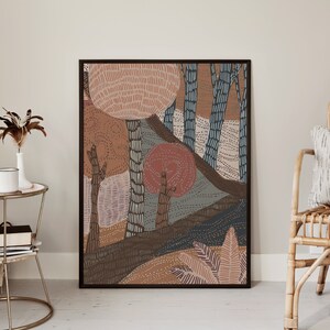 May include: Abstract art print featuring a stylized forest scene with trees, leaves, and a red sun. The print is framed in a black frame and has a brown, orange, and blue color scheme.